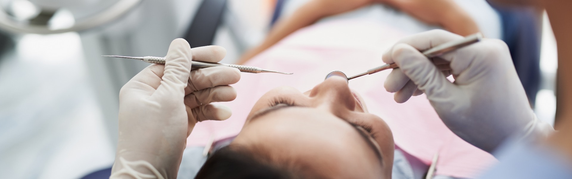 Young lady receiving teeth treatment in modern dental clinic